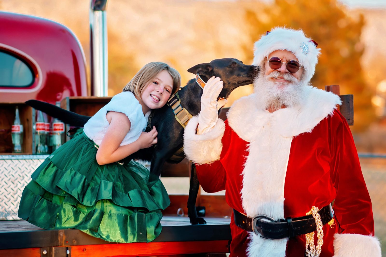 Santa Michael with a girl and her dog beside a vintage truck