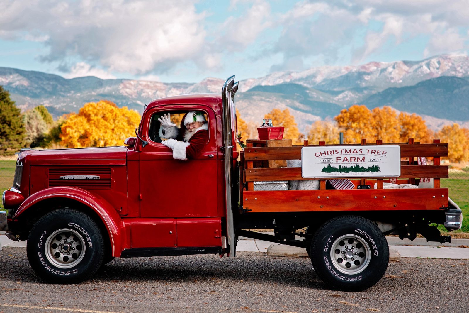 Santa Michael driving a vintage red Christmas tree farm truck