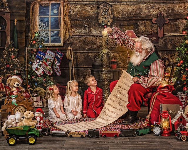Santa Michael reading his list to children in his workshop